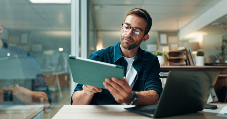 Tablet, glasses and laptop with business man in office for planning, ui designer and app review